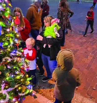 Visitors pause at Gigi Waller’s “Blessing Tree” to attach a hand-written memory or prayer during the 2021 Lighting of the Square events on the Collingsworth County Courthouse Square. Look for Waller’s 2022 “Blessing Tree” on the grounds of the courthouse. Courtesy Photo