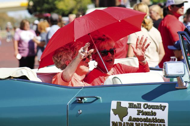 Hall County Picnic Association Parade Marshalls Linda Bowman Huddleston, left, and Debbie Bowman Wiles wave from the backseat of a teal, convertible Cadillac during the parade.