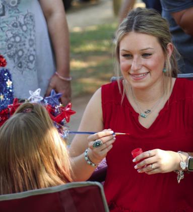 Kady Belle McKee paints children’s faces at the Fourth of July Party in the Park Tuesday, July 4 in Fair Park. The Red River Sun/Elizabeth Tanner
