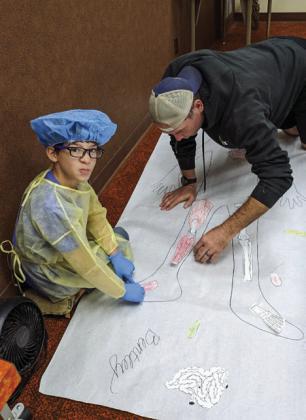 Bentley Sanford performs “surgery” with his father, Ben Sanford.