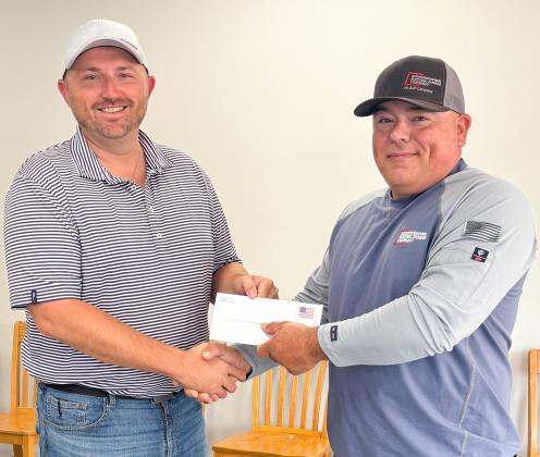 Wellington City Manager Justin Mixon, left, accepts a $10,000 monetary donation in support of the Ellison Park Renovation Project from local AEP-SWECO Lineman Mikey Garza. As citizens of the communities they serve, AEP-SWEPCO strives to donate to nonprofit organizations that improve the quality of life in its communities. On behalf of the Ellison Park Renovation Project Working Group, Mixon expressed his appreciation for the generous gift. City of Wellington