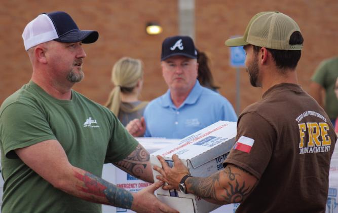 Volunteers unload and distribute water at the community water distribution Monday, Feb. 27 in the Childress High School parking lot. The Red River Sun/Elizabeth Tanner