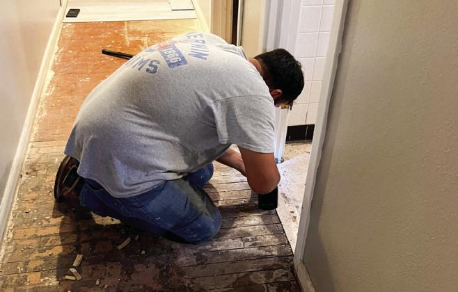 A Knights of Columbus member works in the hallway of Father John Sangabathini’s living quarters during a recent complete parsonage remodel, which included a full bathroom transformation.