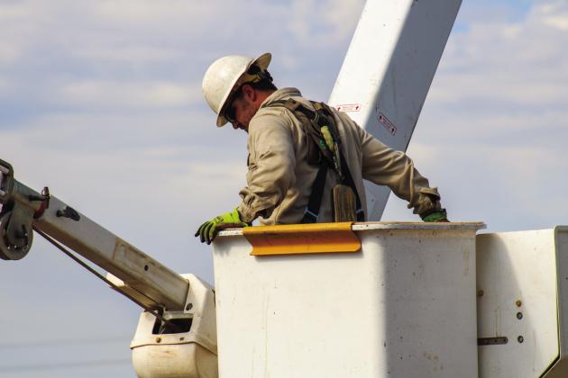 Apprentice Lineman Kervyn Poitevent rises in a buck truck during a demonstration.