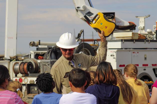 Foreman Cory Bachausen holds up a defibrillator, a device which is sometimes used during poletop rescues to restore a normal heartbeat to lineman that have suffered electrical contact injuries.