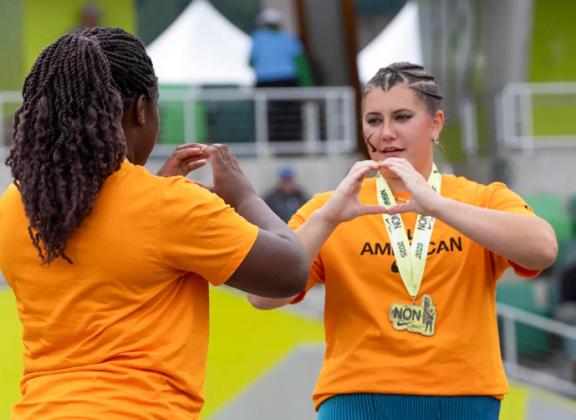 University of Oregon commit Taylor Wiseman practices flashing the “O” with University of Pennsylvania commit Jessica Oji before going on camera for the discus awards during the Nike Outdoor Nationals in Eugene, Ore.
