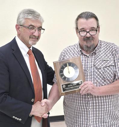 Childress City Attorney Steven Bird (left) receives a plaque from Mayor Cary Preston recognizing his longtime service to the city during a called council meeting Monday night. Bird has served as the city’s attorney for 42 years. The council selected Underwood Law Firm to be the city’s new legal counsel.
