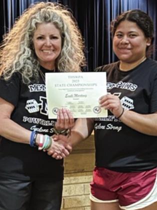Powerlifter Emili Martinez, who recently placed fourth at the state championship, is awarded a certificate of recognition by Coach Michelle Branigan.