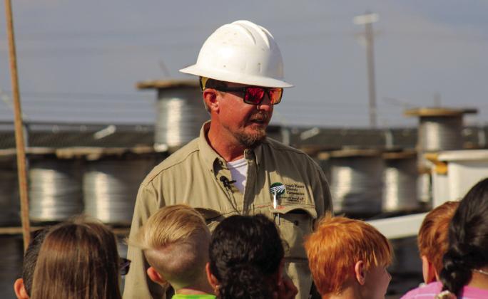 Foreman Cory Bachausen talks area fourth graders through a pole-top rescue demonstration Tuesday morning, Oct. 4 at the South Plains Electric Cooperative Childress Office.
