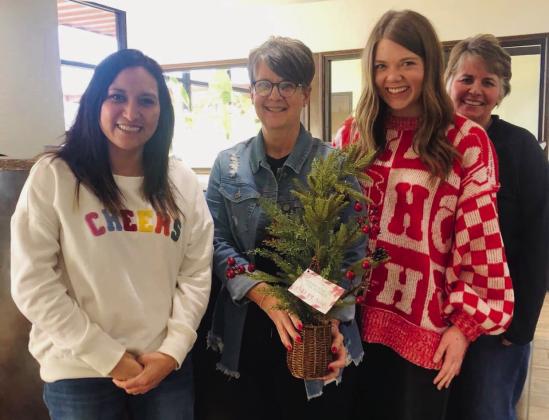 Greenbelt Electric Cooperative’s Maria Avalos, left, Cathy Needham, Cameron Warren and Stacey Breedlove receive the second-place prize for their Christmas cross on the southside of the square.