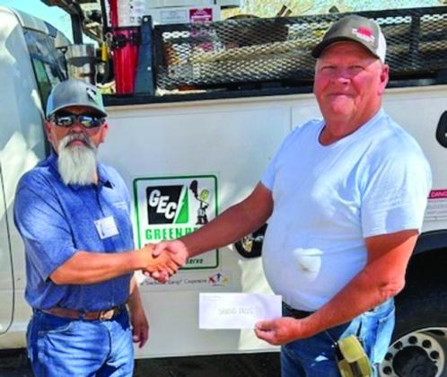Terry Massey, right, accepts an $850 grand prize from Greenbelt Electric Cooperative Lineman Juan Martinez. In appreciation of its membership, Greenbelt Electric Cooperative conducted the cash prize drawings from registered attendees.