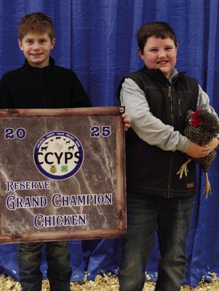 Jacob Lambert exhibits the Reserve Grand Champion Fancy Chicken, purchased by Boedeker.