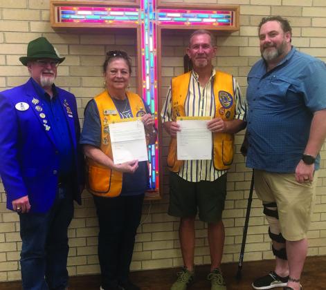 Lions District 2-T1 Governor Roger Estlack, left, presents Lions Margret Wood and Jeff Thomas recognition for 10-year membership in the Wellington Lions Club. District 2-T1 Zone Chair Landon Lambert congratulates Wood and Thomas. The Red River Sun/Bev Odom