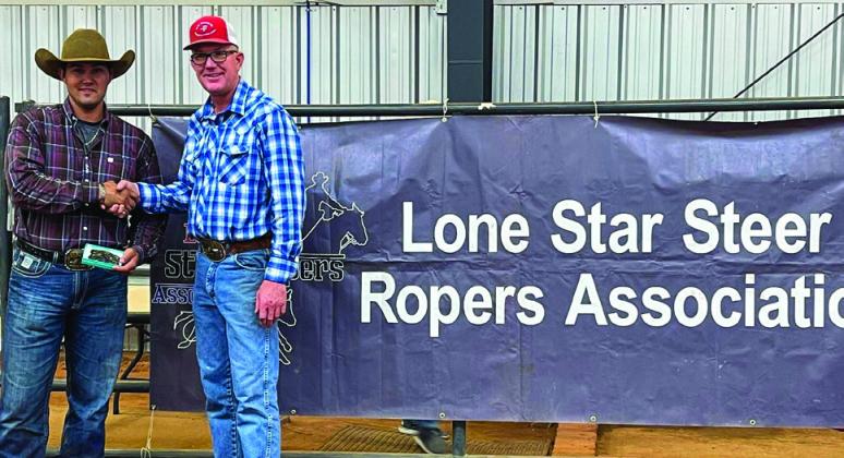 Levi Guitterez, left, accepts a High-Point Buckle from Lone Star Steer Roping Association host Jay Teague.