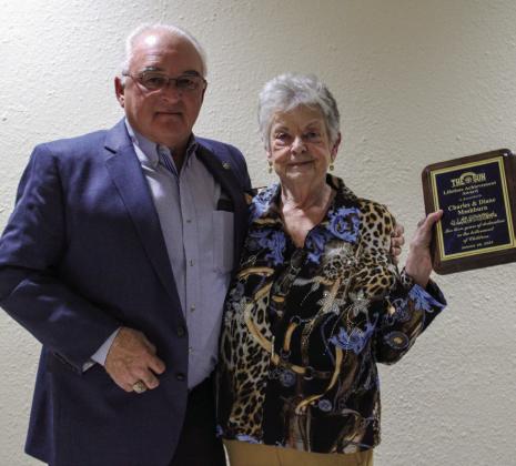 Diane Mashburn accepts the Lifetime Achievement Award, given to her and her husband, Charles Mashburn, from Larry Johnson. For additional Childress Chamber of Commerce Banquet awardees, see 7A. The Red River Sun
