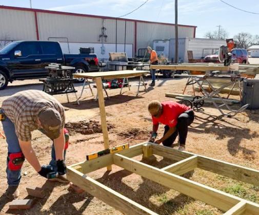 Members of Wellington Lions Club and Amarillo volunteers build ramp frames in the staging area during the Saturday, Feb. 7 construction project.
