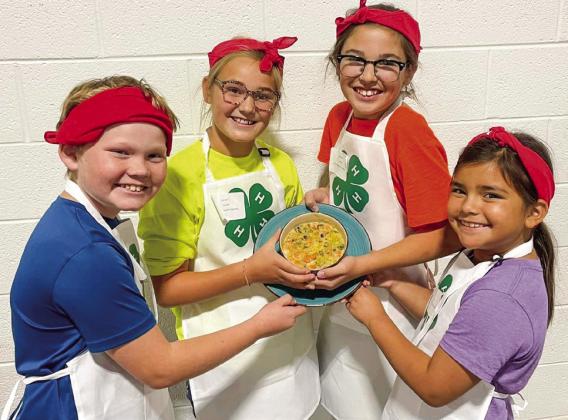 The 4-H Food Challenge team of Barrett Wiebe, left, Ava Kate Inman, Brylnn Kemp and Tylee Wiebe prepare their entrée in the Junior Division.