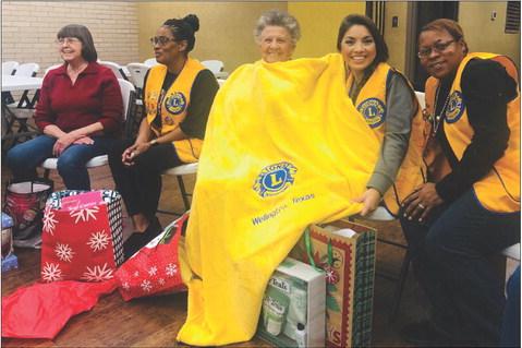 Wellington Lions celebrate the season with a Chinese Christmas gift exchange for their Monday, Dec. 19 meeting. The bright, yellow Lions International stadium blanket, provided by Lion Cynthia Patterson, turned out to be a hot item with Lion Fraya Hammons stealing the treasure for keeps the third time. From left, Nita Day, Patterson, Hammons, Noemi Pena, Angie McDanel. For information on becoming a member of Wellington Lions Club, contact Pena at 806-277-0202. The Red River Sun/Bev Odom