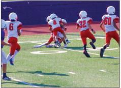 The Red River Sun/Shauna Salinas Eighth grade Wellington’s Dahmian Salinas (4) and Callen Kane (8) make the tackle at the 20-yard line, while Troy Molina (6), Jacob Garcia (32) and Kingston Molina (60) come to assist in the 30-6 Firecracker victory, which started the season last Thursday, Sept. 8 at River Road.