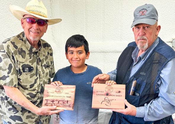 Wellington Junior High School sixth-grader Andrew Skelton, center, accepts the championship award for Wellington Gun Club’s Junior Trap and Junior Skeet competitions at the Saturday, Oct. 18 event. Gun Club Board of Directors Cliff Waller, left, and Kent Riley congratulate Skelton. Wellington Gun Club