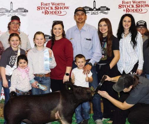 Supported by her crew, fifth-grader Presley Kemp earns 10th place with her Hampshire Barrow at the recent Fort Worth Livestock Show and Rodeo. Presley and Brylynn are the daughters of Kollin and Carle Kemp, of Wellington.