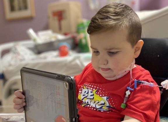 Only a few days after receiving his new kidney in June, five-year-old Clive William Downing plays on his iPad at the Dallas hospital. Courtesy Photo