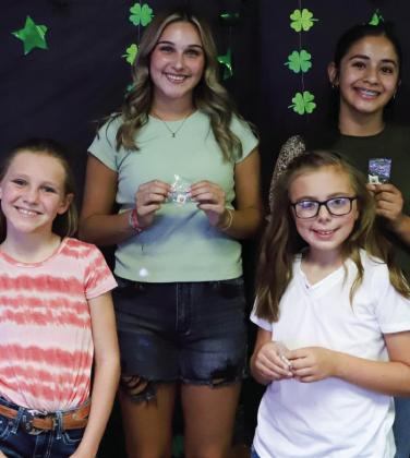 Junior, Intermediate and Senior Division 4-Hers display pins received for completing Record Books. Front row, from left: Raylie Sims, Briley Holton. Back row, from left: Emma Flores, Hazel Estrada.