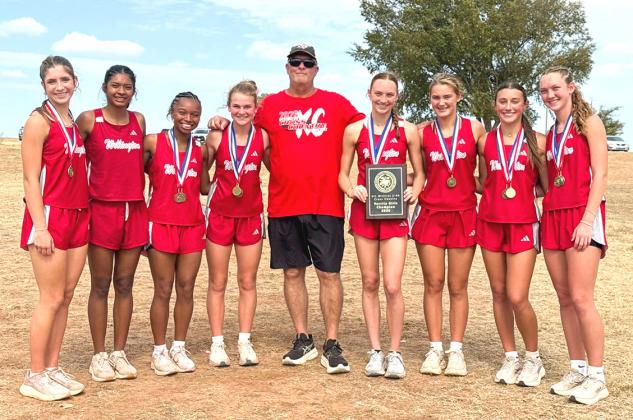 The Wellington Lady Rockets earn the District 2-2A cross country team championship Tuesday, Oct. 13 at the Quanah Country Club. From left: Anna Henard, Priscilla Marentes, Aleah Lewis, Halle Hedrick, Coach Travis Nicks, Taytum Kane, Ava Kate Inman, Claire Kane, and Kaesyn Kane. WELLINGTON HIGH SCHOOL