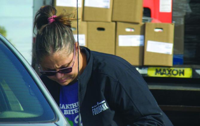 High Plains Food Bank’s Rachael Maxwell checks in a client at the November distribution of Community Supplemental Food Program boxes in Childress.