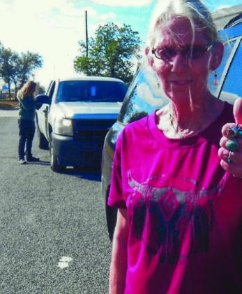 Natalie Wages displays her opinion of the Community Supplemental Food Program (CSFP) with a wide smile and thumbs up at the November distribution. In background is CSFP Coordinator Josh Oldham.