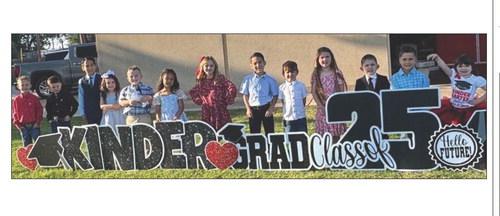 Leslie Wiebe’s Wellington Elementary School kindergarten students pause for a picture in front of Wellington Elementary School Friday morning, May 9. From left: William Patterson, Crease Myers, Angel Luis Perez, Presley Dwyer, Jackson Carter, Mia Harris, Novelaya Roberts, Abraham Paz Chirinos, Rafe Holmes, Avery Bell, Cole Castor, Cooper Cox, Stassi Jeffrey.
