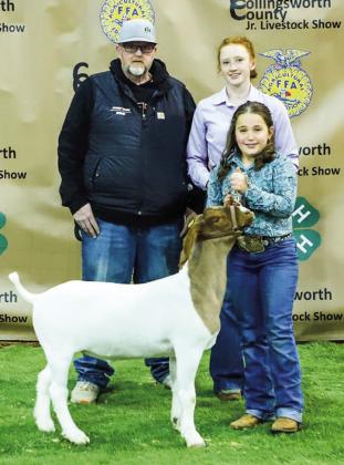 Dixie Thomas exhibits her second-place class 3 goat with buyer Buzzard Roost Farms, represented by Jeremy Page and Bailey Page.