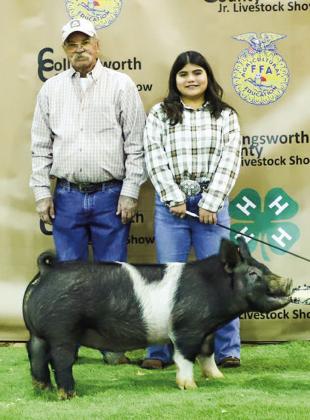 Realea Davila shows her third-place class 2 cross swine with buyer Tommy Coleman.