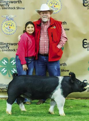 Isabella Padilla exhibits her third-place class 3 cross swine with buyer Farm Bureau Insurance, represented by Durk Green.