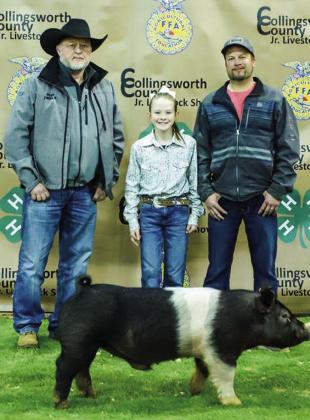 Kenlea Martin shows her third-place class 1 Hampshire swine with buyers Huddleston Cotton Co. and Rock Inn Café, represented by Kevin Huddleston and Wade Wiles.