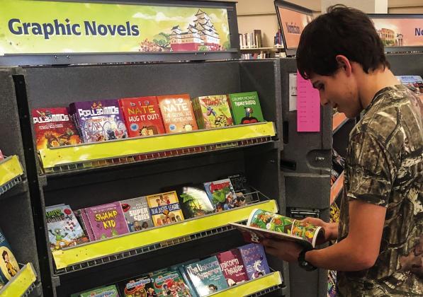 An avid reader, Wellington High School junior Marcus Lopez grabs a book from the display case during Collingsworth Public Library’s recent Literati Book Fair. Not able to put the book down, Lopez ended up purchasing his find. The Red River Sun/Bev Odom