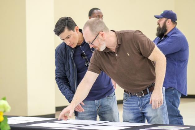 Childress Spark Secretary Brian Pierce overlooks blueprint plans with Fair Park Amphitheater Restoration Project Groundbreaking Ceremony guests Friday, Feb. 27 at the Fair Park City Auditorium. The Red River Sun/Elizabeth Tanner