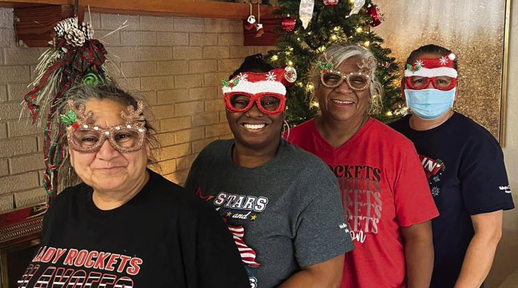 Getting ready for the holiday season, certified nurse aids at Wellington Care Center line up in front of the fireplace. Courtesy Photo