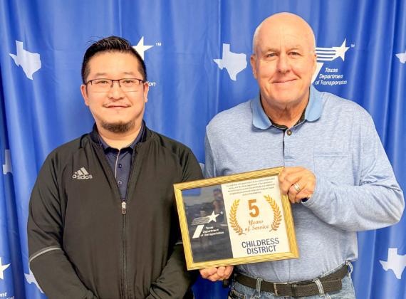 Childress District of the Texas Department of Transportation Engineer Darwin Lankford presents a five-year service award to Lin Xie, Transportation, Planning and Design. Additional five-year recipients included Colby Gilbert, Cottle County maintenance, and Toby Taylor, Foard County Maintenance. Also awarded was Nathan Herring, Knox County maintenance, for 10 years of service.