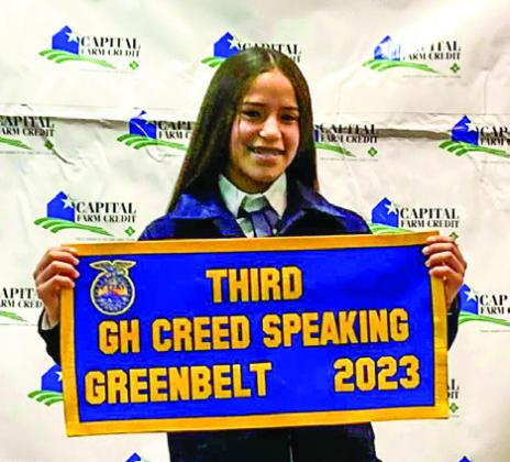 Memphis freshman Jaelyn Goxiolaacceptsthethird-place Greenhand Creed Speaking banner at the Greenbelt District FFA Banquet Monday, Dec. 4 in Memphis.