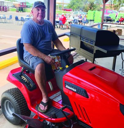Mark Huntress displays his riding mower, which was won in the anniversary drawings at Bartlett’s Lumber &amp;amp; Hardware. Huntress, who also won the Pit-Boss griddle, said he shopped all three days of the special sale. Courtesy Photo