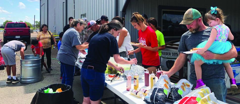 Served by Luwana Needham and Karrie Hudson, customers file through the food line during Bartlett’s 85th anniversary customer appreciation cookout. Many had already been in the store to take advantage of the 20% off Bucket Bonanza sale.