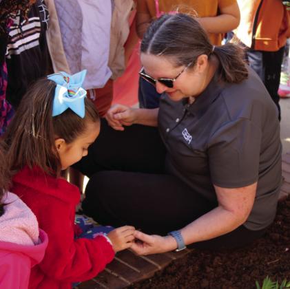 Childress Elementary School kindergarten students get their hands dirty, planting drought-resistant lantanas Thursday, April 20 during GBA Grows for Earth Day. GBA employees Donna Anders, Gary Clark and Dane Fuller taught the students about Earth Day, as well as improved the soil in the school's flower bed, while planting the flowers. The Red River Sun/Elizabeth Tanner