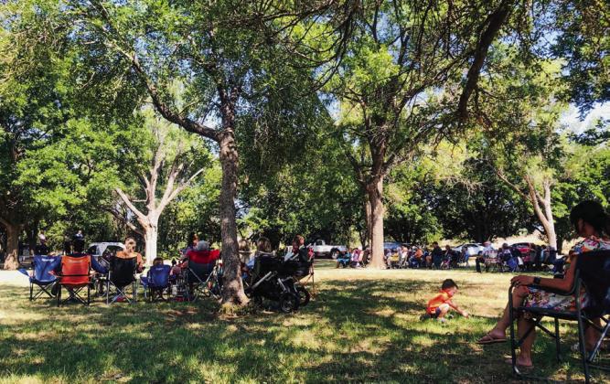 Venturing a short distance from his family, three-yearold Bexton Brooks, son of Travis and Kelsey Brooks, of Childress, makes the most of his Sunday morning worship time at Pioneer Park, adding to his grasshopper collection. The Red River Sun/Bev Odom