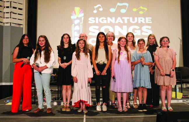 Monson Music Studio vocal students perform signature songs, including “What a Wonderful World” by Louis Armstrong, “I Hope You Dance” by Leanne Womack, “Wide Open Spaces” by the Dixie Chicks and more, at the Palace Theater Sunday, May 7. From left: Lacy Teichroeb, Ava Barlow, Saylee Ochoa, Selah Smith, Gerald Monson, Heather Peters, Shirley Weir, Liesel Schaefer, Summer Neufeld, Grace Peters, Maggie Tillman and Harper Hall. The Red River Sun/Elizabeth Tanner
