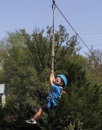 Three-year-old Will Patterson takes a turn on the zipline during the Collingsworth County 4-H Enrollment Party Saturday, Sept. 10 at Panfork Baptist Camp. Other activities included swimming, fishing, playing volleyball and eating hotdogs.