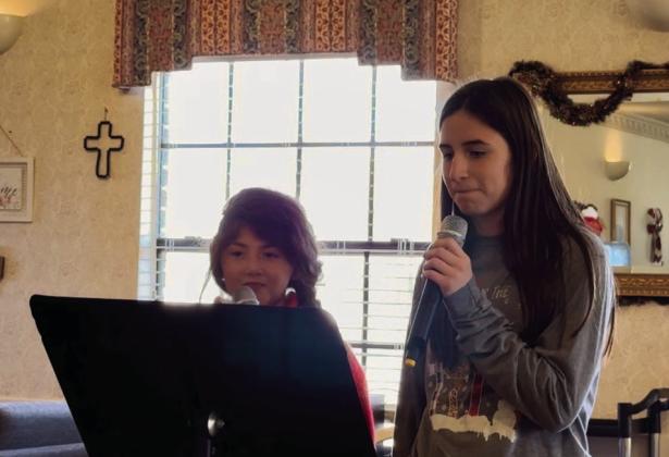 Monson Music Studio’s Bella Blu Sanders and Saylee Ochoa perform at Cottage Village Friday, Dec. 20.
