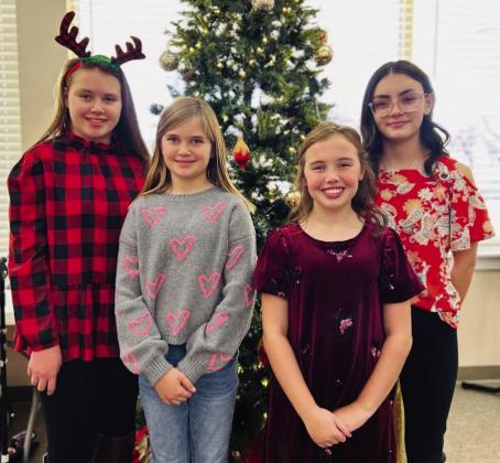 Monson Music Studio students, including Ava Barlow, Chelsea Harms, Rafe Barlow and Sophia Derr, bring good tidings and toy to Wellington’s Parkview Manor Assisted Living Saturday, Dec. 21.
