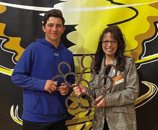 Memphis High School senior Jase Middleton presents a cactus sculpture, which he welded out of horseshoes at the Memphis Independent School District (ISD) Career Training Center, to Region 16 Education Service Center Coordinator of Accountability, Assessment and School Improvement Christine Scroggs. Photo Courtesy of Memphis ISD