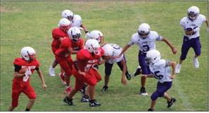 Seventh-grade Firecracker Josue Davila (6) runs the ball while a host of Firecrackers hold back Spearman in their first home game of the season last Thursday, Sept. 15, winning 6-0. The Red River Sun/Shauna Salinas